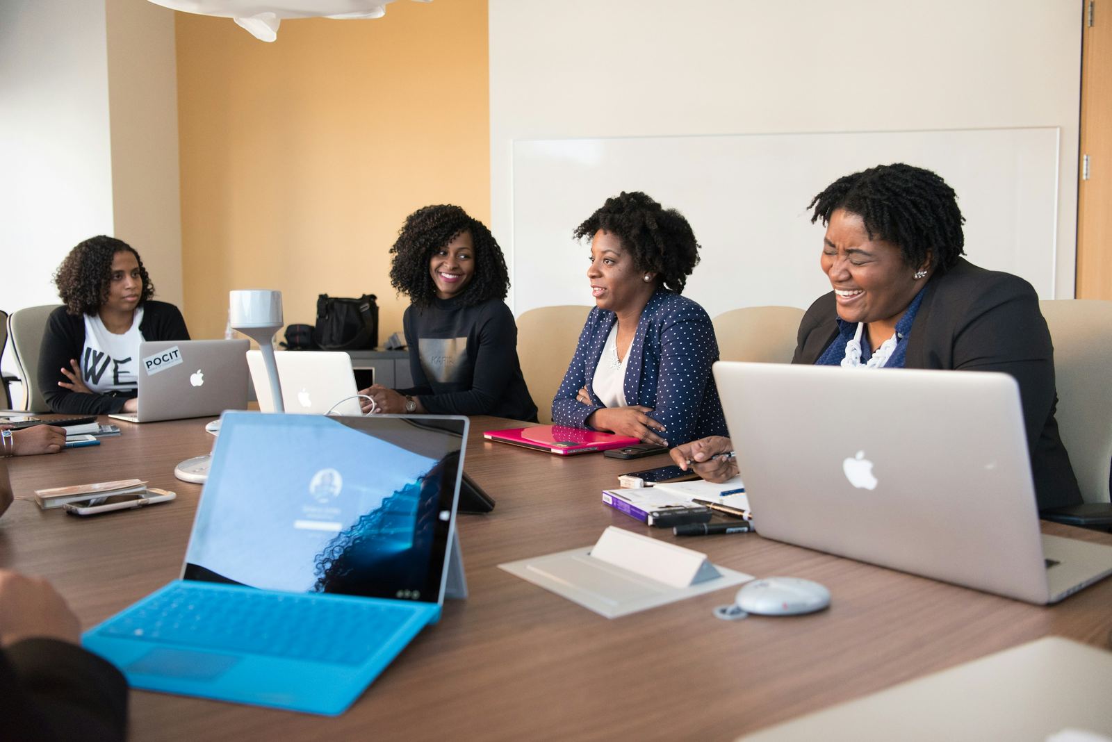 An HR team reviewing workforce information together on laptops